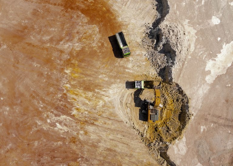 Aerial view of gold mining activity with excavators and haul trucks, symbolizing gold supply factors referenced in the Seasonal Insight and long-term 4-year market cycles.