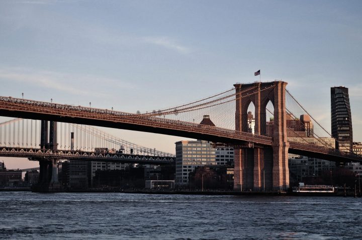 Brooklyn Bridge at sunset over the East River in New York, symbolizing US equity market focus and S&P 500 seasonality.